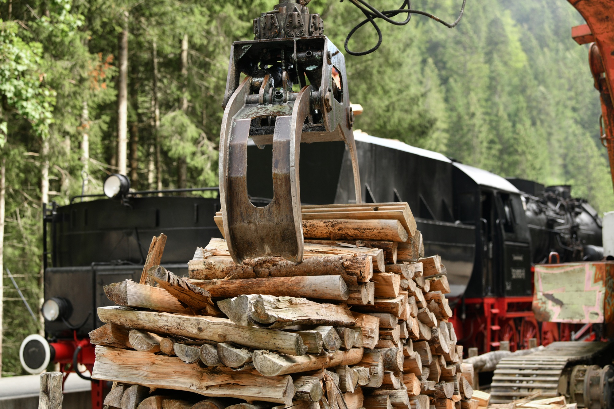 A scrap locomotive loading firewood into a vintage steam locomotive